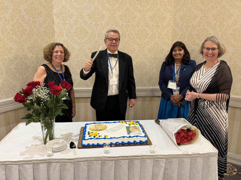 Buchwald preparing to slice cake, with (from left) Susan Haber, Anita Mehta, and Amy Balija.