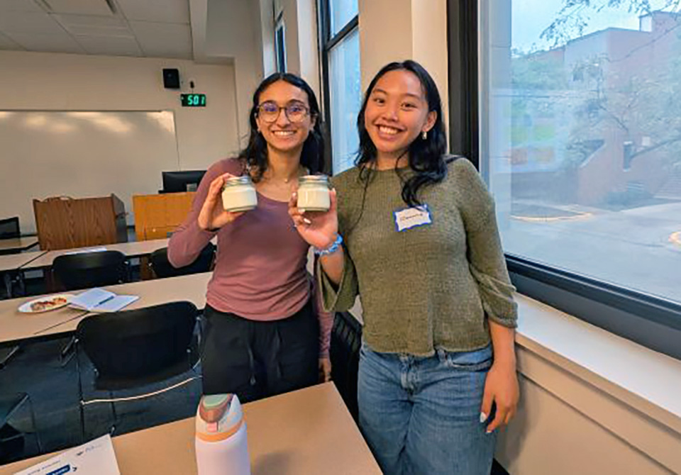 Two chemists proudly display the butter (in jars) they made at the Chicago YCC event 