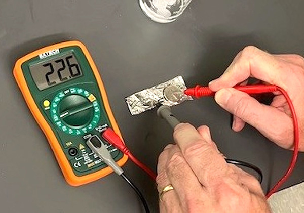 Photo showing how to use a multimeter to measure voltage in this coil battery experiment